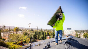 Worker installing solar panels on a home in Los Angeles